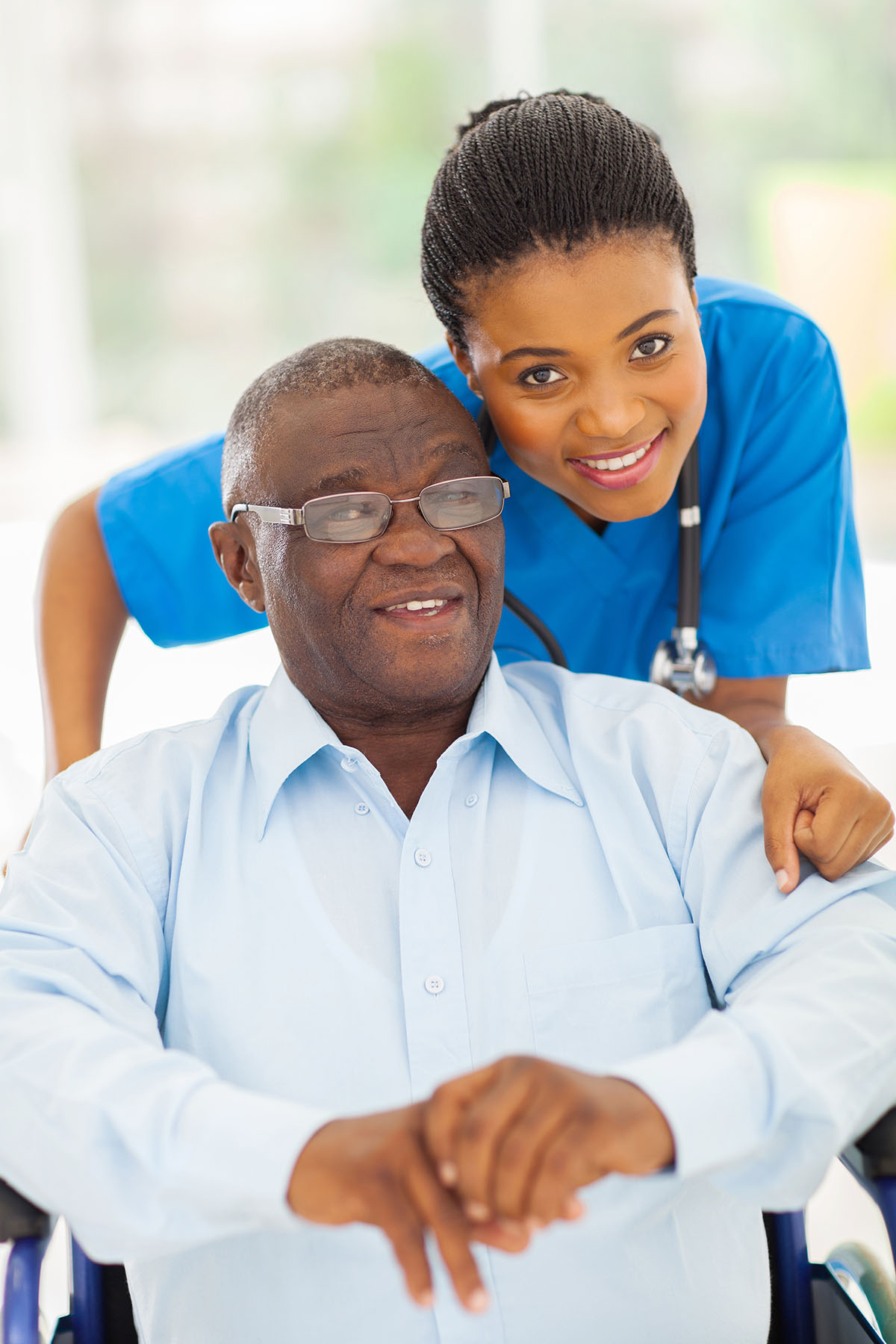 elderly african american man and caring young caregiver at home