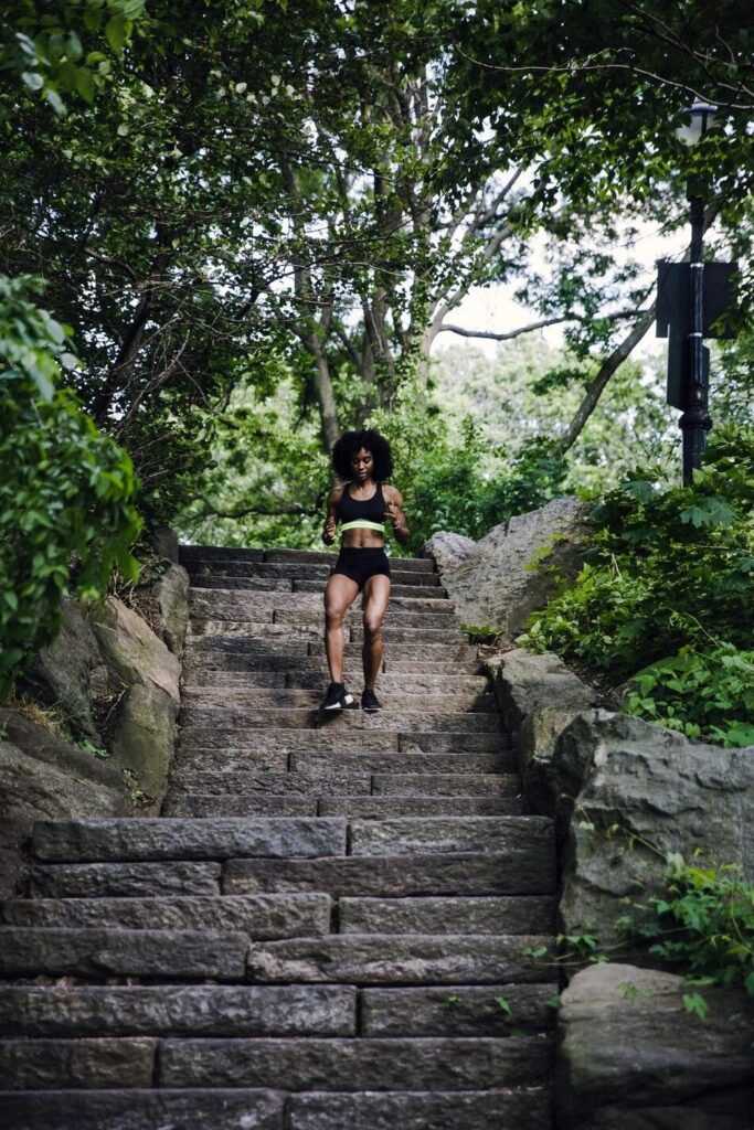 Person running down stone steps in nature.