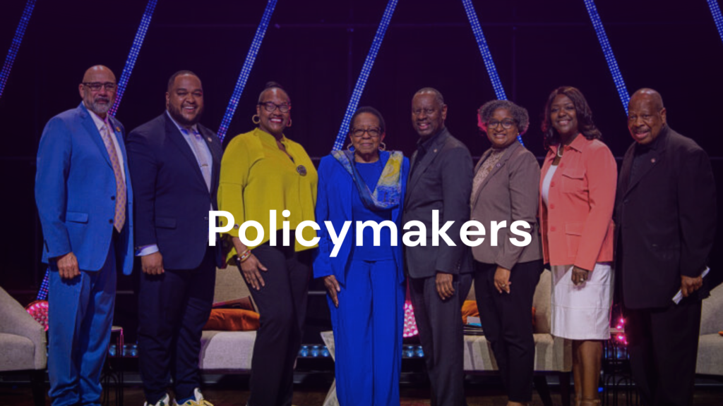 A diverse group of policymakers posing confidently on stage.